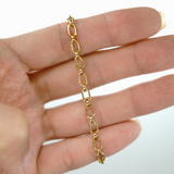 Gold chain bracelet on a hand with a white background