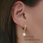 Model wearing Perla Flex Hoops, highlighting the elegant drop of the freshwater pearl