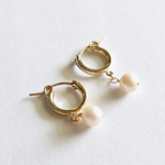 Close-up of the back of gold-filled hoops with secure clasp and pearl attachment
