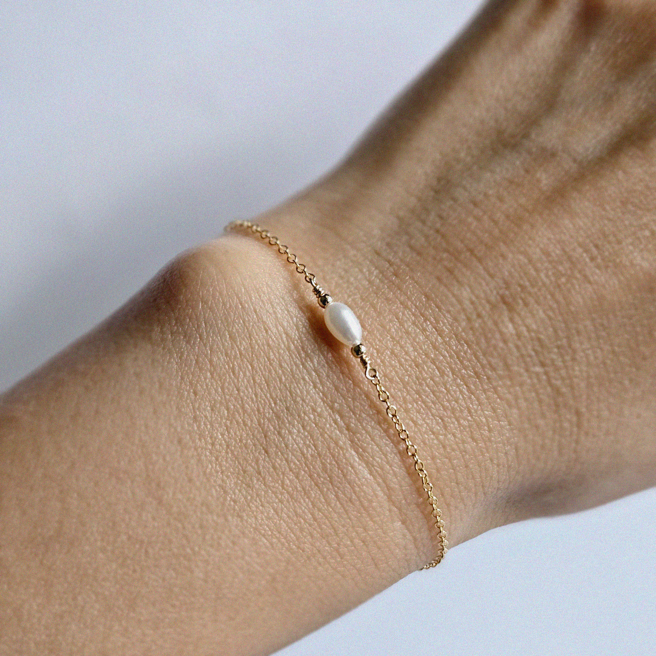 Elegant gold and pearl bracelet styled solo on wrist
