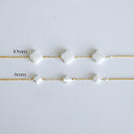 Two gold bracelets with white beads on a light gray background, labeled '10mm' and '6mm'.