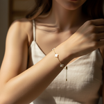 Woman wearing a delicate bracelet with small four leaf clover charm on a blurred background