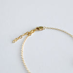 Gold bracelet on a light gray background