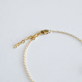 Gold bracelet on a light gray background