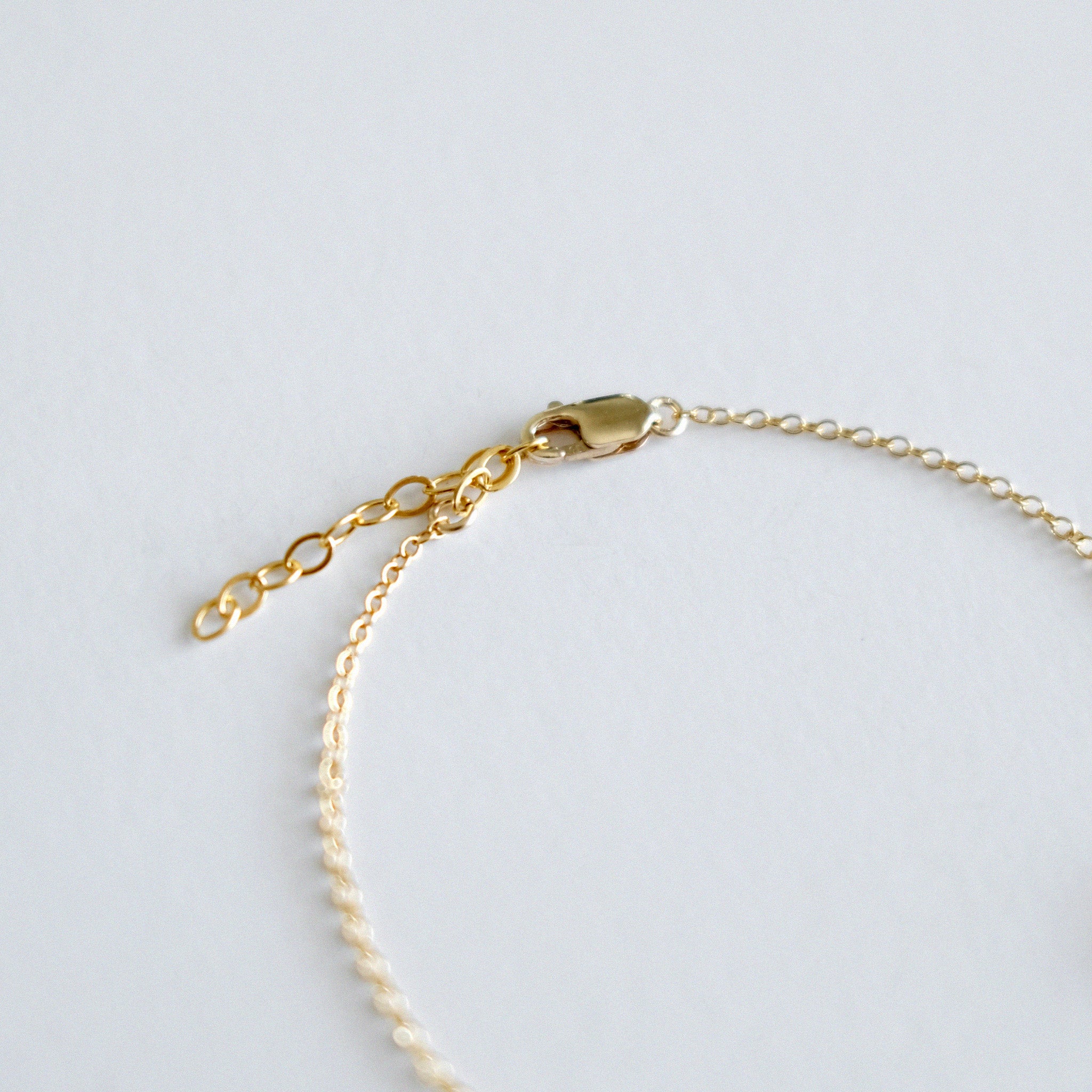 Gold bracelet on a light gray background