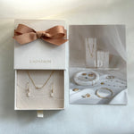 Jewelry set in a box with a bow, featuring the brand 'LAONDRIM'.
