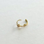 Backside of 14K gold hoop earring with polished clasp and clover charm detail