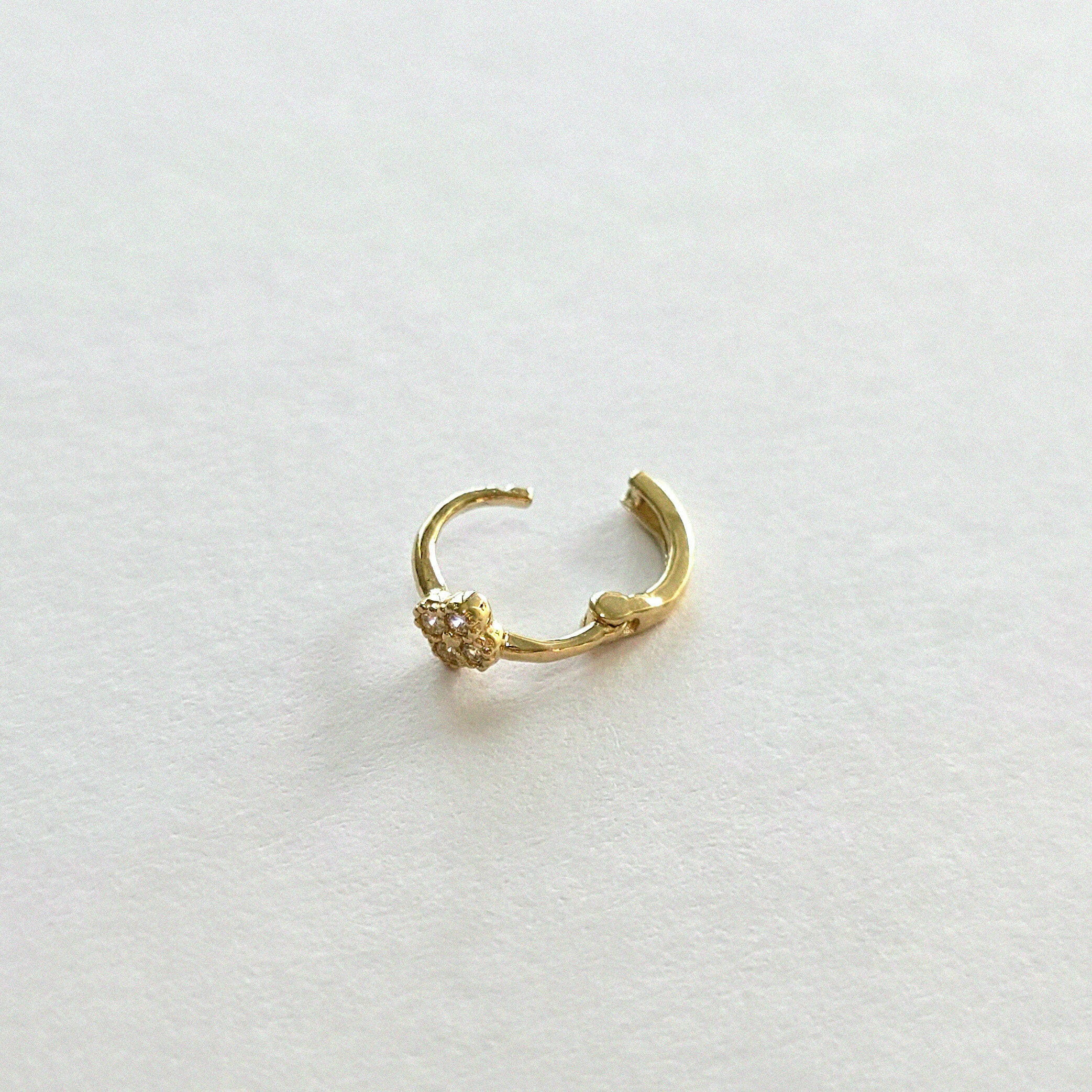 Backside of 14K gold hoop earring with polished clasp and clover charm detail