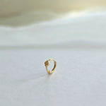 Close-up of clover-accented gold hoop earring shown from side profile