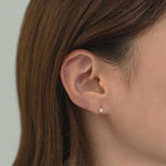 Lil Clover Huggie Hoop worn in lobe piercing with sparkling clover detail