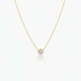 Gold necklace with a round diamond pendant on a white background