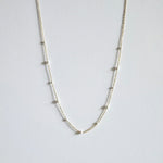 Mixed pearls necklace laid flat, showing graduated Swarovski pearls on a delicate gold chain