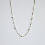 Mixed pearls necklace laid flat, showing graduated Swarovski pearls on a delicate gold chain