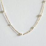Zoomed-in view capturing pearl surface and gold chain texture with soft shine