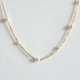 Zoomed-in view capturing pearl surface and gold chain texture with soft shine