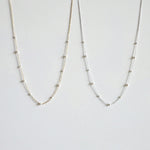 Gold and silver pearl necklaces side by side featuring subtle size variations