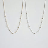 Gold and silver pearl necklaces side by side featuring subtle size variations