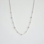 Mixed pearls necklace laid flat showing graduated Swarovski pearls on a delicate silver chain