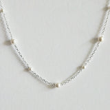 Zoomed-in view capturing pearl surface and silver chain texture with soft shine