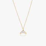 Gold necklace with a whale tail pendant on a white background