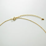 Gold chain necklace on a light gray background