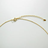 Gold chain necklace on a light gray background