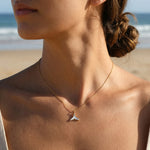Woman wearing a necklace with a beach in the background