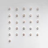 Mother of pearl initial charms spelling out 'ABCDEFGHIJKLMNOPQRSTUVWXYZ' on a light gray background