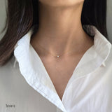 Necklace with a small pendant worn by a person in a white shirt, with '3mm' text.