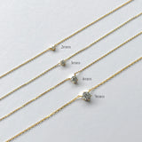 Gold chain necklace with varying width labels on a light gray background
