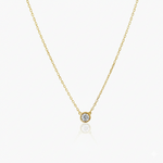 Gold necklace with a small round diamond pendant on a white background