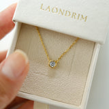 Gold necklace with a round pendant in a 'LAONDRIM' box