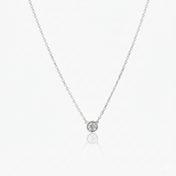Silver necklace with a small round pendant on a white background