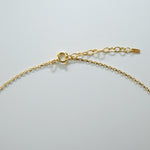 Gold chain necklace on a light gray background