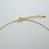Gold chain necklace on a light gray background