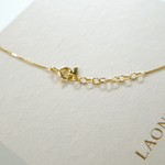 Gold necklace on a white background with 'LAONDRIM' branding.