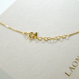Gold necklace on a white background with 'LAONDRIM' branding.