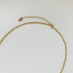 Close-up of interlocking 3D-oval-shaped links in gold, capturing texture and polish