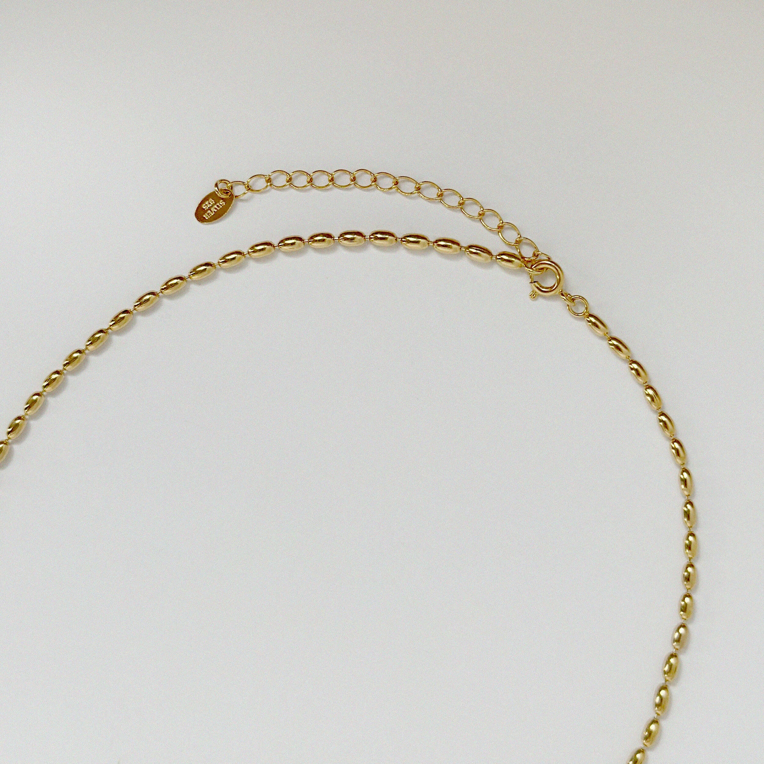 Close-up of interlocking 3D-oval-shaped links in gold, capturing texture and polish