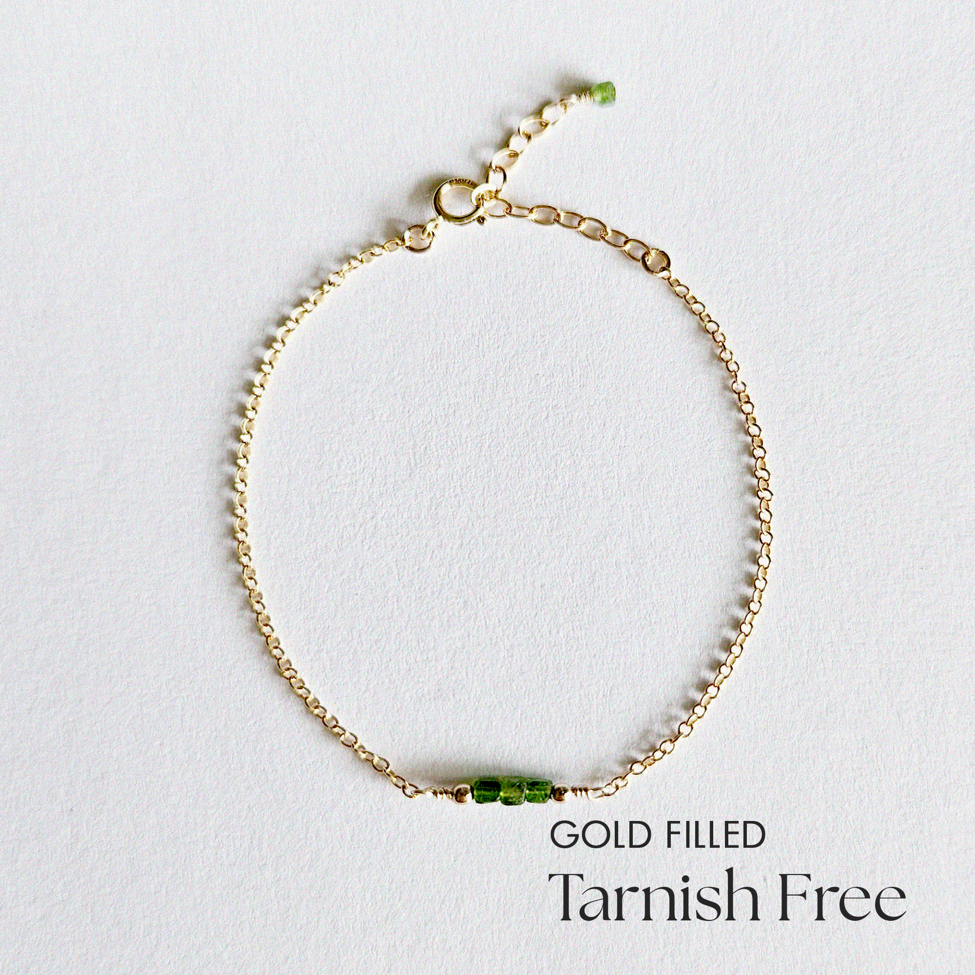 Top-down view of Gold Filled Worth II Bracelet showing centered green stones