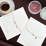 Necklace on display with 'Laondrin' branding, surrounded by small containers of beads.