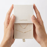 Hands holding a box with gold necklaces and 'LAONDRIM' branding.