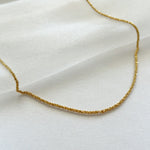 Close-up of sterling gold basa necklace on shimmery soft fabric