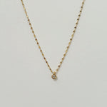 Crystal Accent Necklace laid flat in a soft curve, featuring a single sparkling cubic zirconia