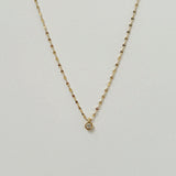 Crystal Accent Necklace laid flat in a soft curve, featuring a single sparkling cubic zirconia