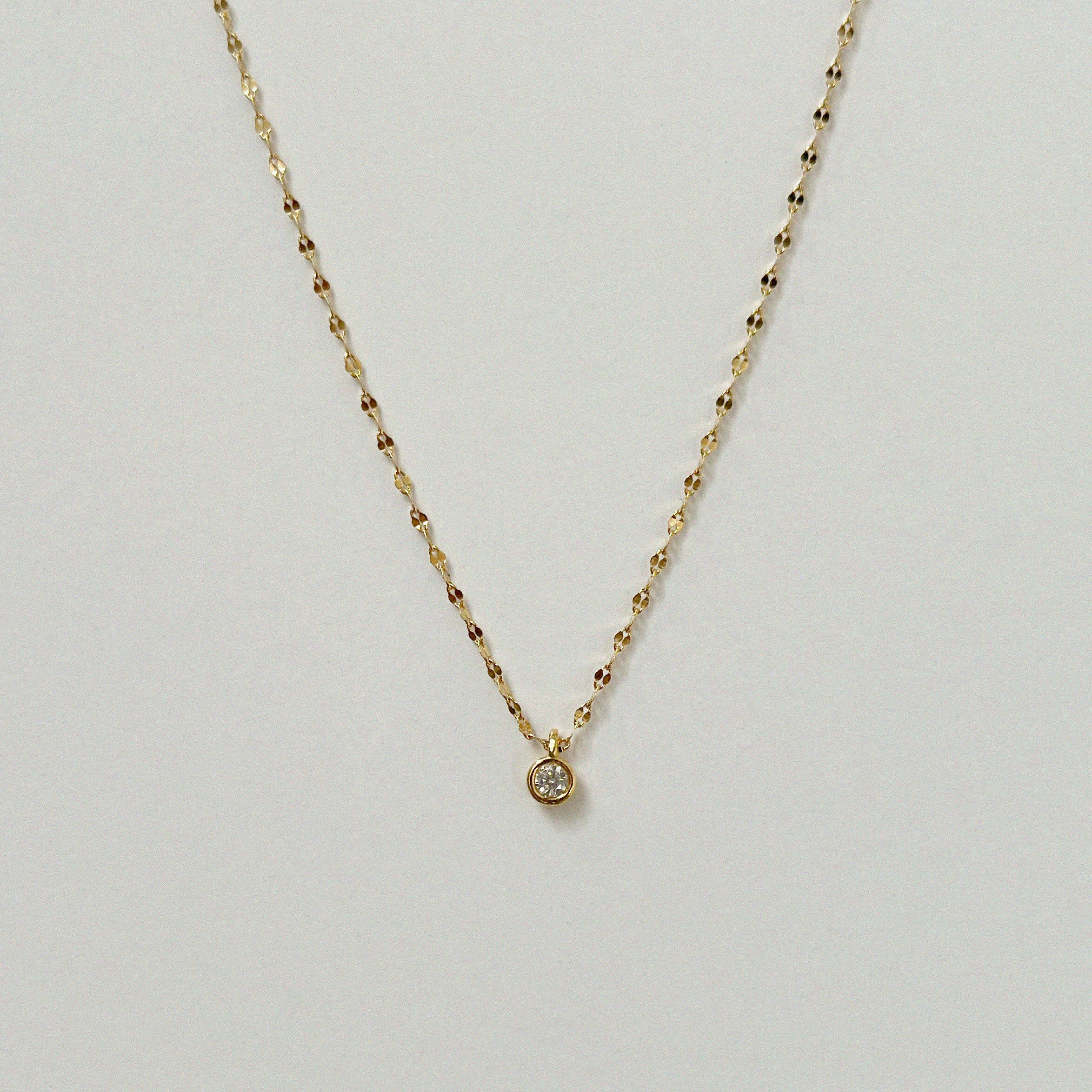Crystal Accent Necklace laid flat in a soft curve, featuring a single sparkling cubic zirconia