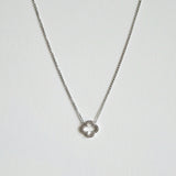 Crystal clover silver necklace  with sparkling pendant laid flat in a soft curve