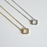Gold and silver clover necklaces displayed side by side with cubic zirconia accents