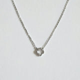 Close-up highlighting the four-leaf shape and crystal sparkle with dainty chain