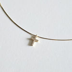 Close-up of cubic zirconia cross on fine gold snake chain with polished finish